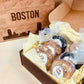 Box of pastries with 'Boston' engraved on a wooden box in the background